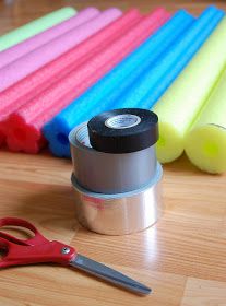 several rolls of tape and scissors on a wooden table next to some colored markers with one rolled up in the middle