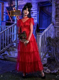 a woman in a red dress holding flowers