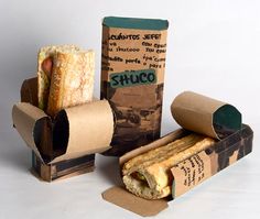 an assortment of food items displayed on white surface with box and paper wrapper in foreground