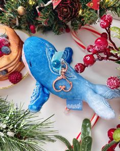 a blue whale keychain sitting on top of a table next to christmas decorations