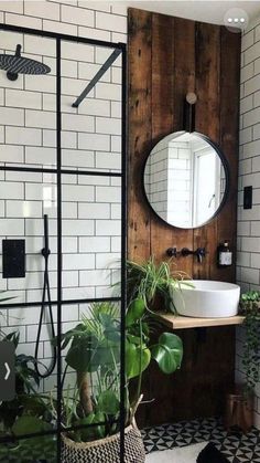 the bathroom is decorated in black and white tile, with plants on the counter next to the shower