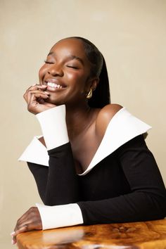 a woman sitting at a table with her hand on her chin