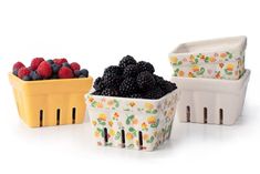 three containers with berries in them sitting next to each other