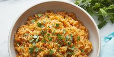 a white bowl filled with rice and garnished with cilantro