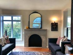 a living room with two couches and a fire place in it's center