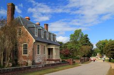 an old brick house with people walking down the street