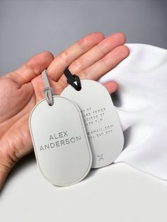 a person holding two tags in their hands