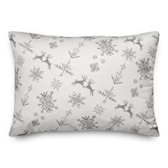 a white pillow with snowflakes and reindeers on the front, in black and white