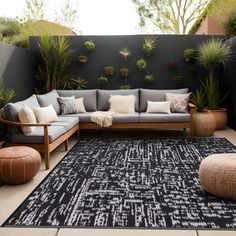 an outdoor living area with couches, tables and potted plants