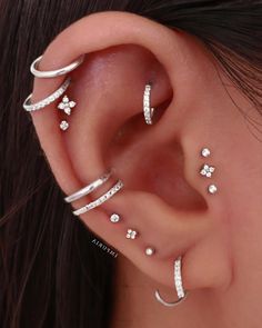 an ear with three different types of piercings on the top and bottom of it