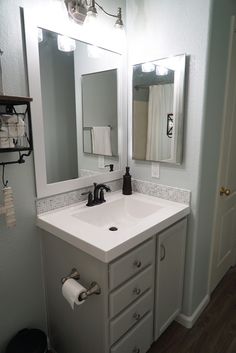 a bathroom sink with two mirrors above it