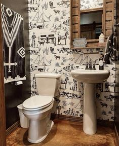 a white toilet sitting next to a sink in a bathroom under a wooden framed mirror