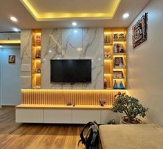 a living room filled with furniture and a flat screen tv mounted on a wall next to a wooden floor