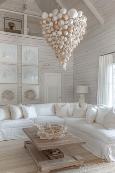 a living room filled with white furniture and lots of pillows on top of the couch