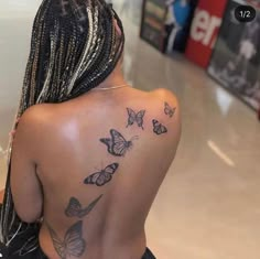 the back of a woman's body with many butterflies on her upper and lower back