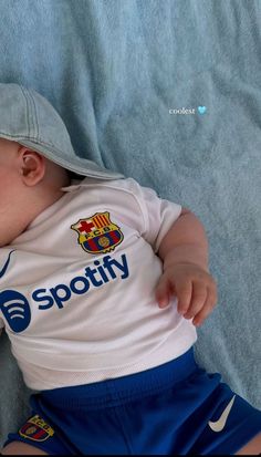 a baby laying on top of a bed wearing a shirt and shorts with the word spotty printed on it