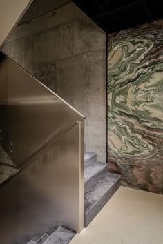 an escalator in a building with marble walls and stairs leading up to the second floor