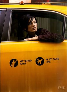 a woman leaning out the window of a taxi