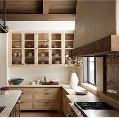 a kitchen filled with lots of wooden cabinets and counter top space next to a window