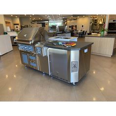 a large kitchen island in the middle of an open floor plan with stainless steel appliances