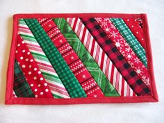 a red and green patchwork wallet on a white surface with polka dots, snowflakes, and christmas trees