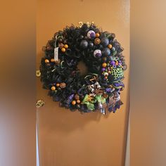 a wreath is hanging on the wall next to a door with halloween decorations around it