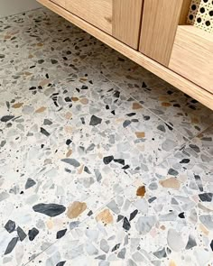 a bathroom with a sink, cabinet and countertop made out of stone tiles on the floor