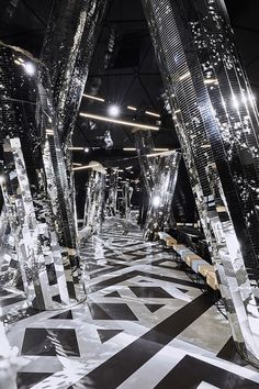 an artistic black and white photo with mirrors on the floor, lights in the background