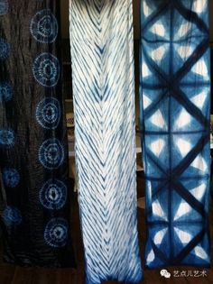 three blue and white tie - dyed curtains hanging on a wall