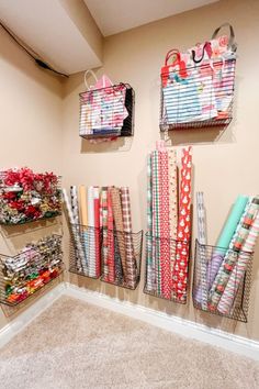 the wall is filled with wrapping paper and other crafting supplies in baskets on it