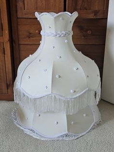 a white vase sitting on top of a carpeted floor