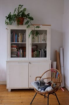 a wicker chair sitting in front of a book shelf