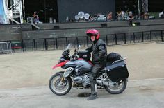 a person sitting on a motorcycle in front of a stage