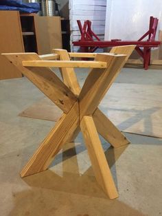 a wooden table sitting on top of a floor next to a red chair in a room