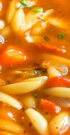 pasta and vegetable soup in a red bowl