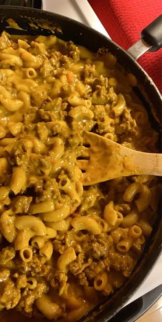 a skillet filled with macaroni and cheese on top of a stove