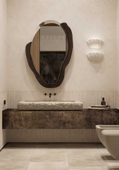 a bathroom with a toilet, sink and mirror in it's centerpieces