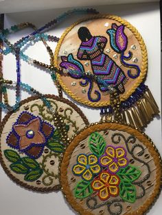 four embroidered ornaments are on display in a box