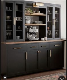 a black and gold china cabinet with glass doors on the front, open shelves above it