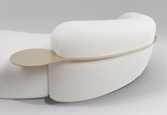 a white couch with a wooden spoon sticking out of it's backrests