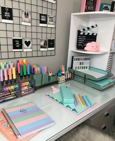 the desk is organized with pens, notebooks and other office supplies in pastel colors