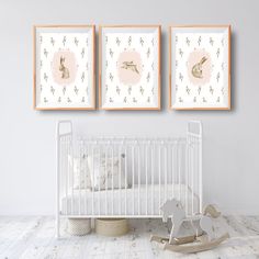 a baby's room with three framed pictures on the wall