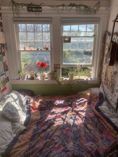 a bedroom with two windows and a quilt on the bed in front of the window