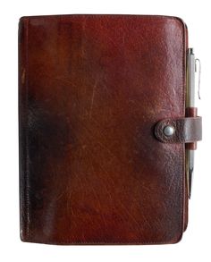 a brown leather notebook with a pen in it