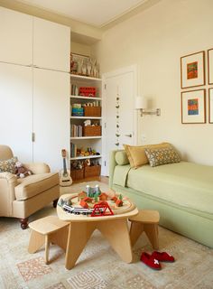 a living room filled with furniture and a small table in front of a couch on top of a rug