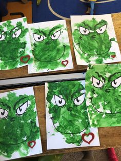 some green paper with faces on them and hearts in the middle, sitting on a table