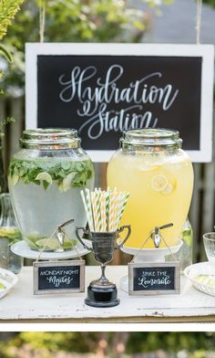 a table topped with drinks next to a sign