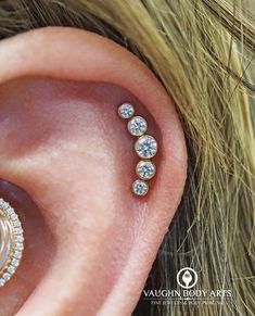 a woman's ear is shown with three diamonds