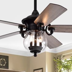 a ceiling fan with two light bulbs hanging from it's blades in a living room