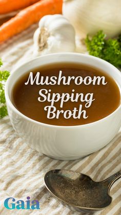 a bowl of mushroom dipping broth next to carrots and celery